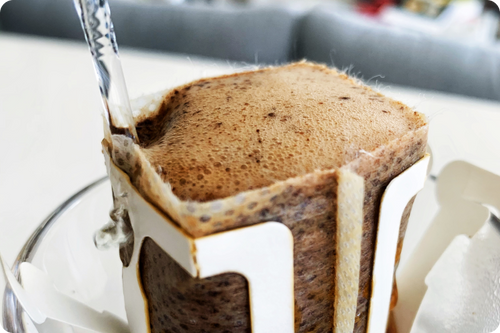 Fresh pour over coffee in bloom stage - air bubbles forming as hot water is poured on top of coffee grounds