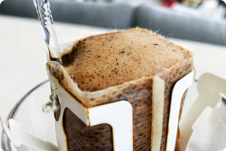 Fresh pour over coffee in bloom stage - air bubbles forming as hot water is poured on top of coffee grounds